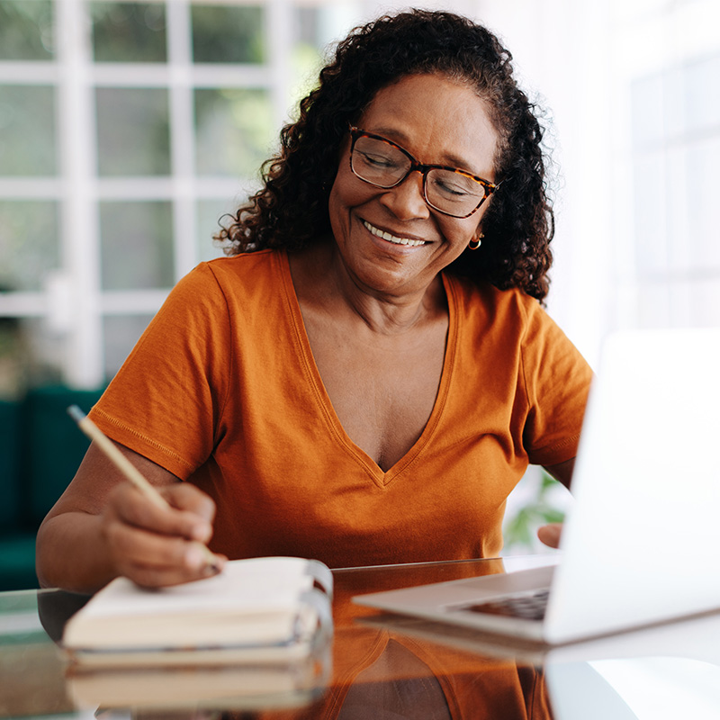 Happy senior woman drafting her last will in her journal in Hamilton County, IN