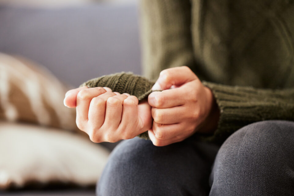 Clasped hands in anxiety on lap, symbolizing legal support for civil protection orders