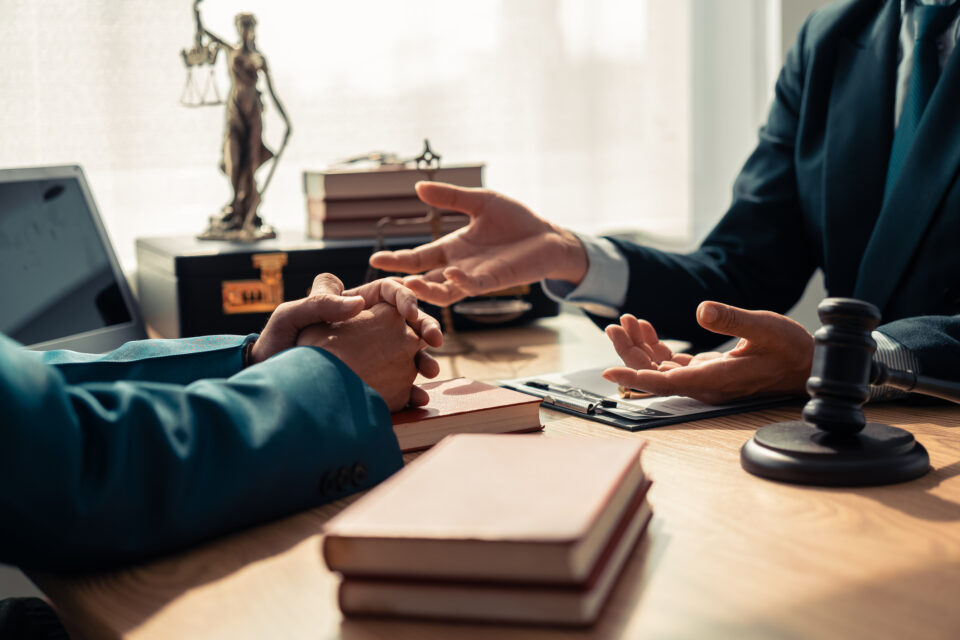 Professional legal consultation at a desk with Lady Justice statue, law books, and gavel, symbolizing expert legal services